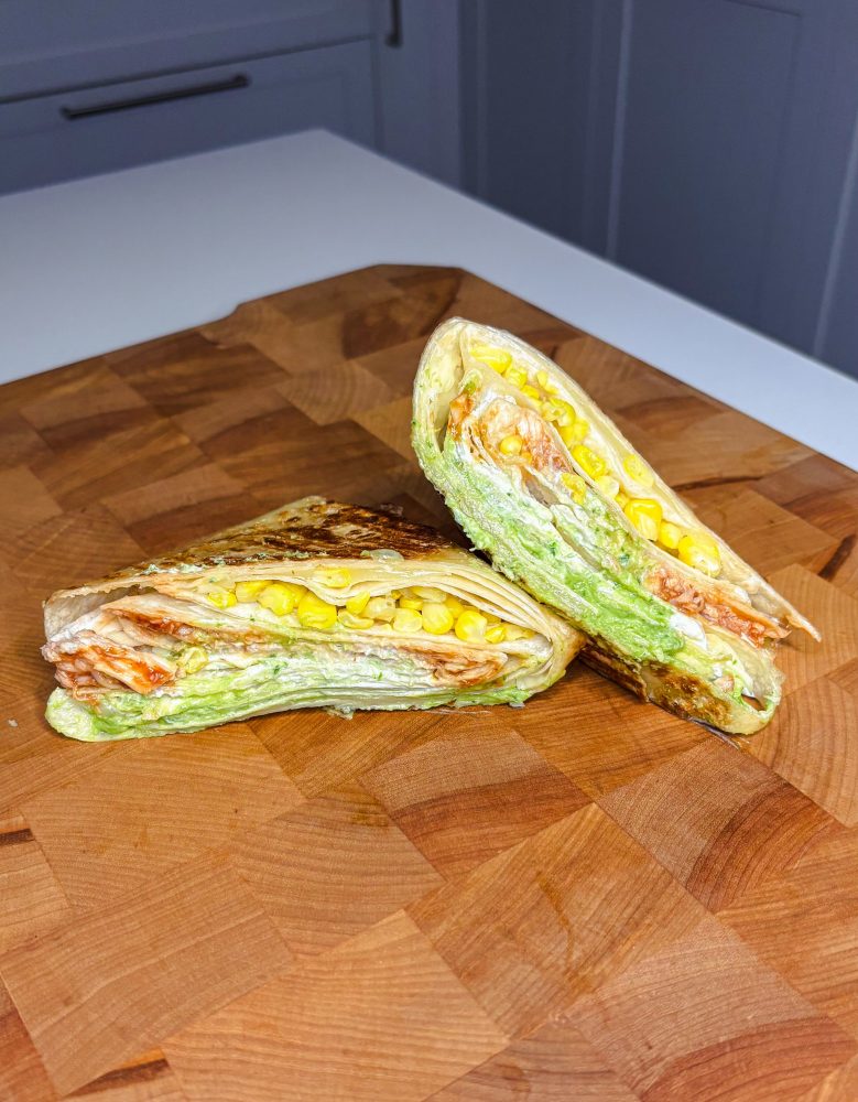 Wrap à la dinde BBQ garni d’avocat, maïs, crème sure et fromage, plié puis grillé jusqu’à ce qu’il soit croustillant.